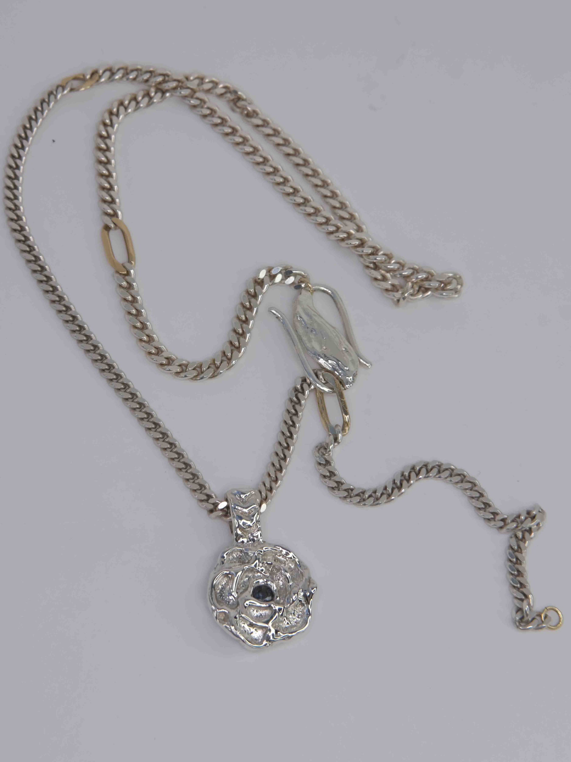 Delikate, wachsmodellierte Blütenblatt-Halskette – handgefertigt und sandgegossen aus 925 Sterling-Silber mit einem blauem Saphir im Zentrum. Die Panzerkette wird durch 9k Gold-Glieder kombiniert, was der Kette einen edlen und einzigartigen Charme verleiht. Diese Schmuckkreation ist designed und made in Berlin.