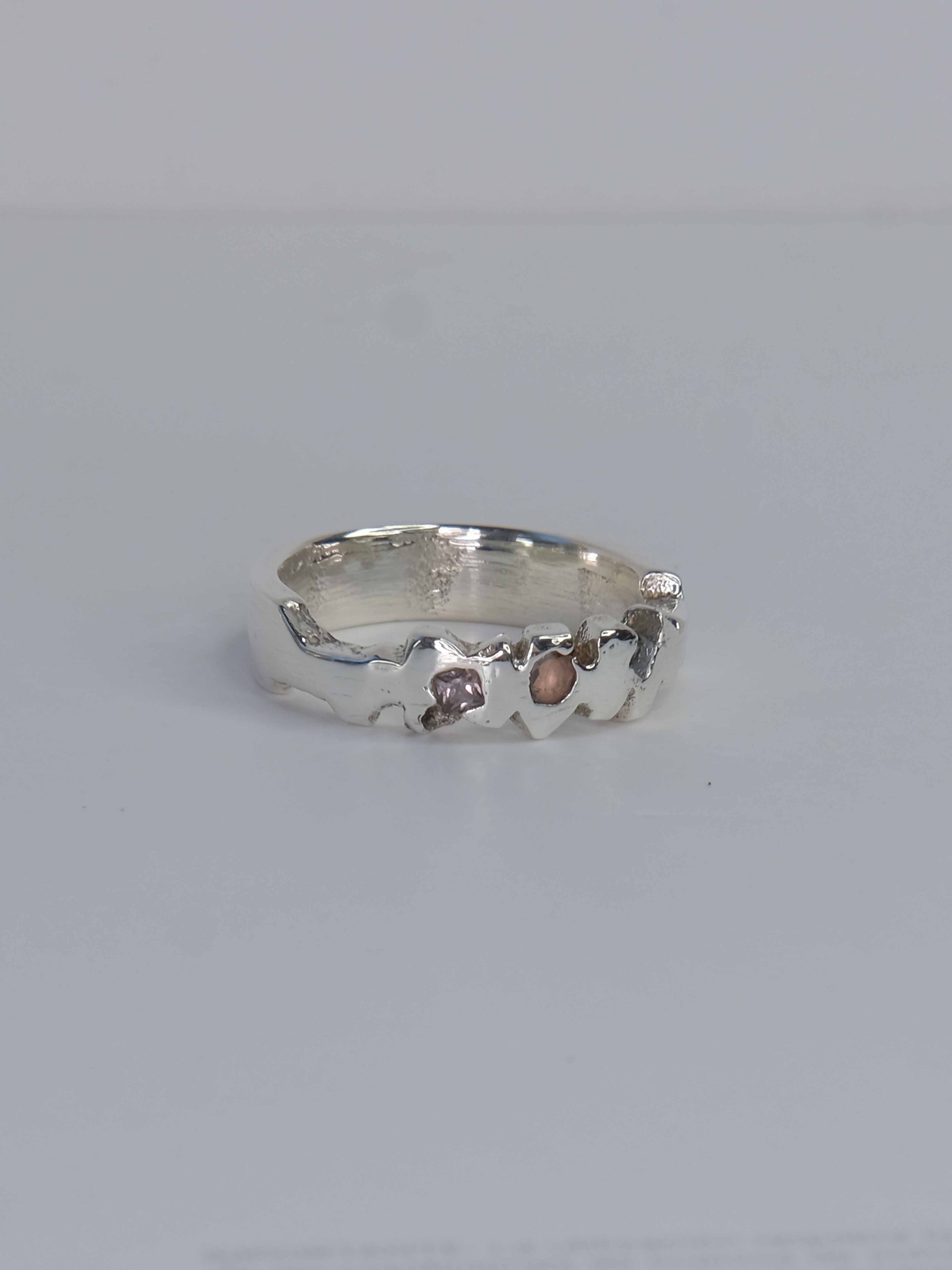 Tankwa Ring aus 925 Sterling-Silber mit strukturierten Oberflächen, die an die scharfen Wüstensteine des Tankwa Karoo Nationalparks erinnern. Verziert mit kleinen quadratischen Saphiren in verschiedenen Blau- und Lilatönen. Handgefertigt und designed in Berlin.