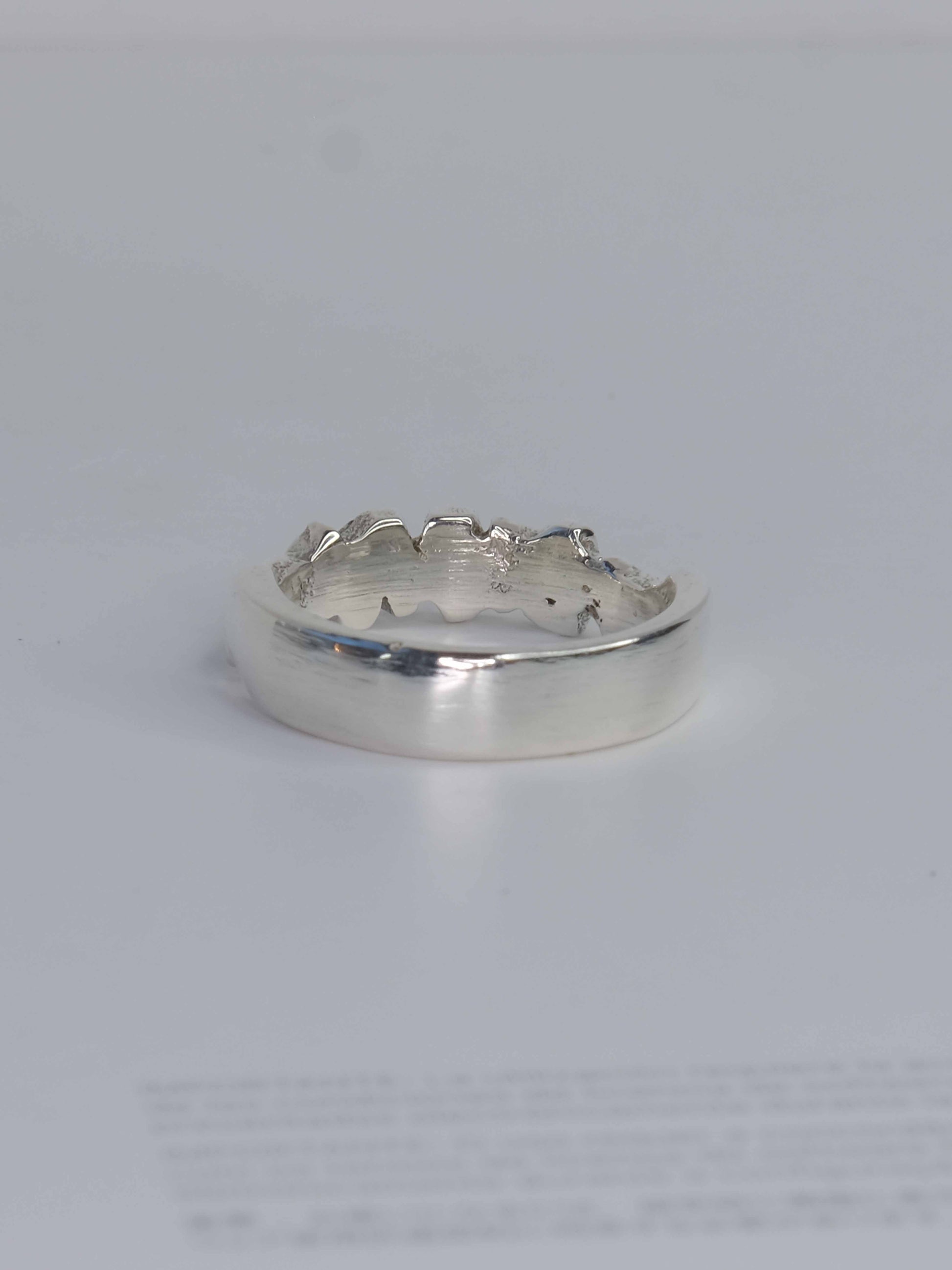 Tankwa Ring aus 925 Sterling-Silber mit strukturierten Oberflächen, die an die scharfen Wüstensteine des Tankwa Karoo Nationalparks erinnern. Verziert mit kleinen quadratischen Saphiren in verschiedenen Blau- und Lilatönen. Handgefertigt und designed in Berlin.