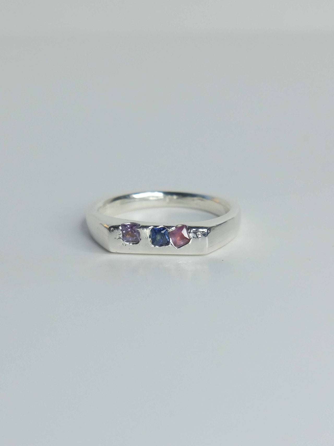 Handgefertigter Celestia Siegelring aus 925 Sterling-Silber mit glatter Oberfläche in schlanker Form, durch Sandguss gefertigt mit blauen violetten und pinken Saphiren – designed und made in Berlin.