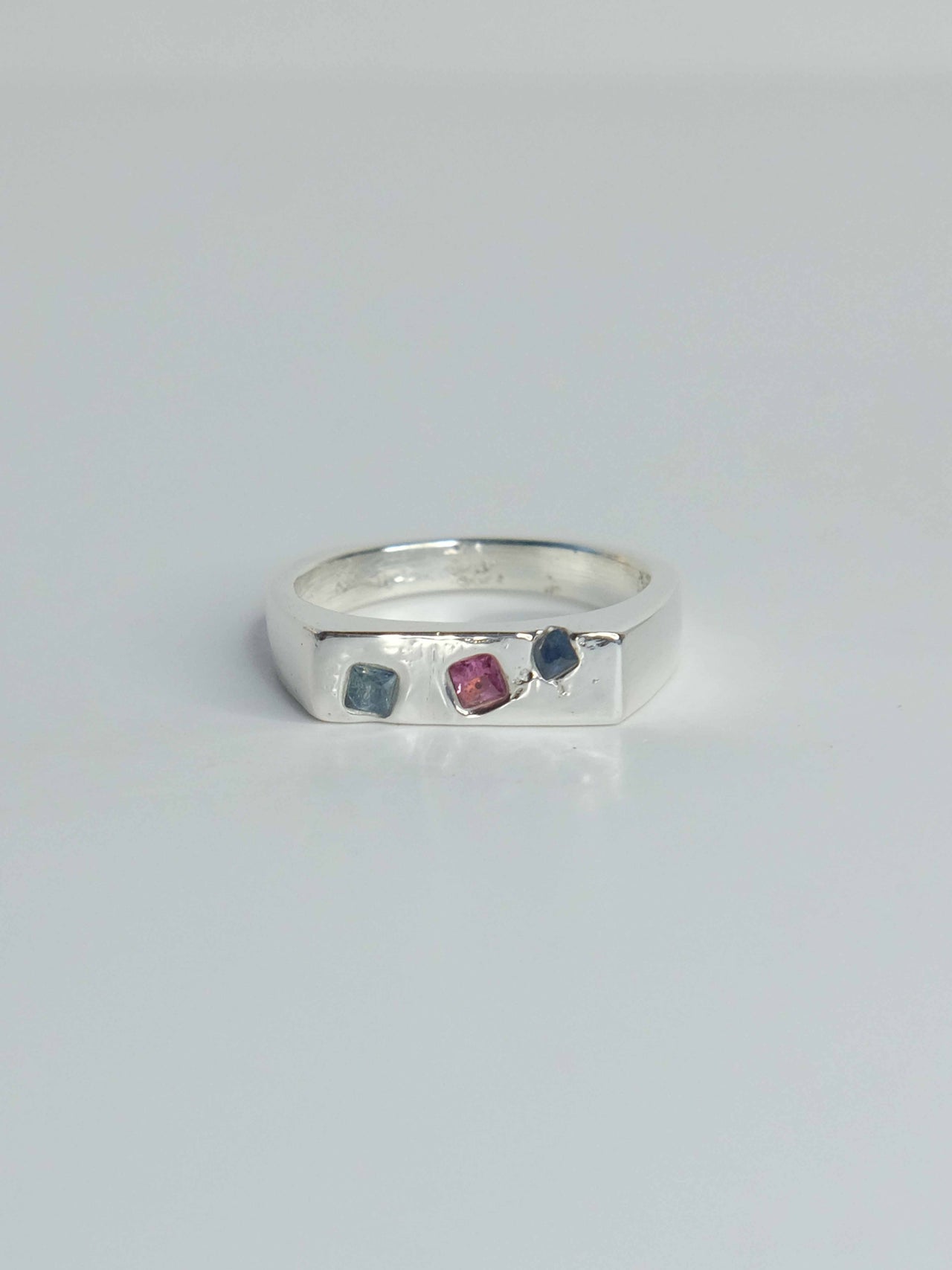 Handgefertigter Celestia Siegelring aus 925 Sterling-Silber mit glatter Oberfläche in schlanker Form, durch Sandguss gefertigt mit blauen violetten und pinken Saphiren – designed und made in Berlin.