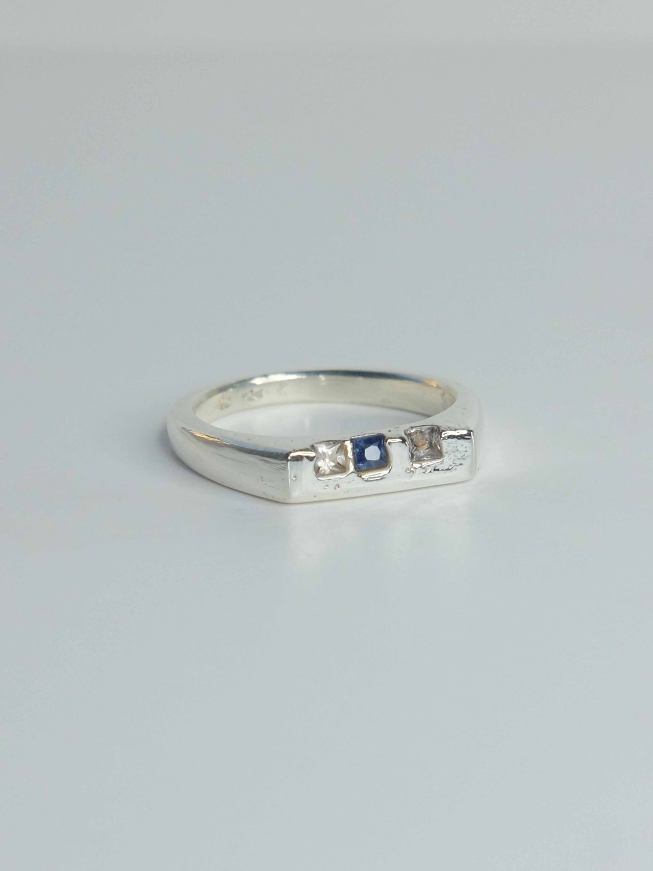 Handgefertigter Celestia Siegelring aus 925 Sterling-Silber mit glatter Oberfläche in schlanker Form, durch Sandguss gefertigt und blauen und transparenten Saphiren – designed und made in Berlin.