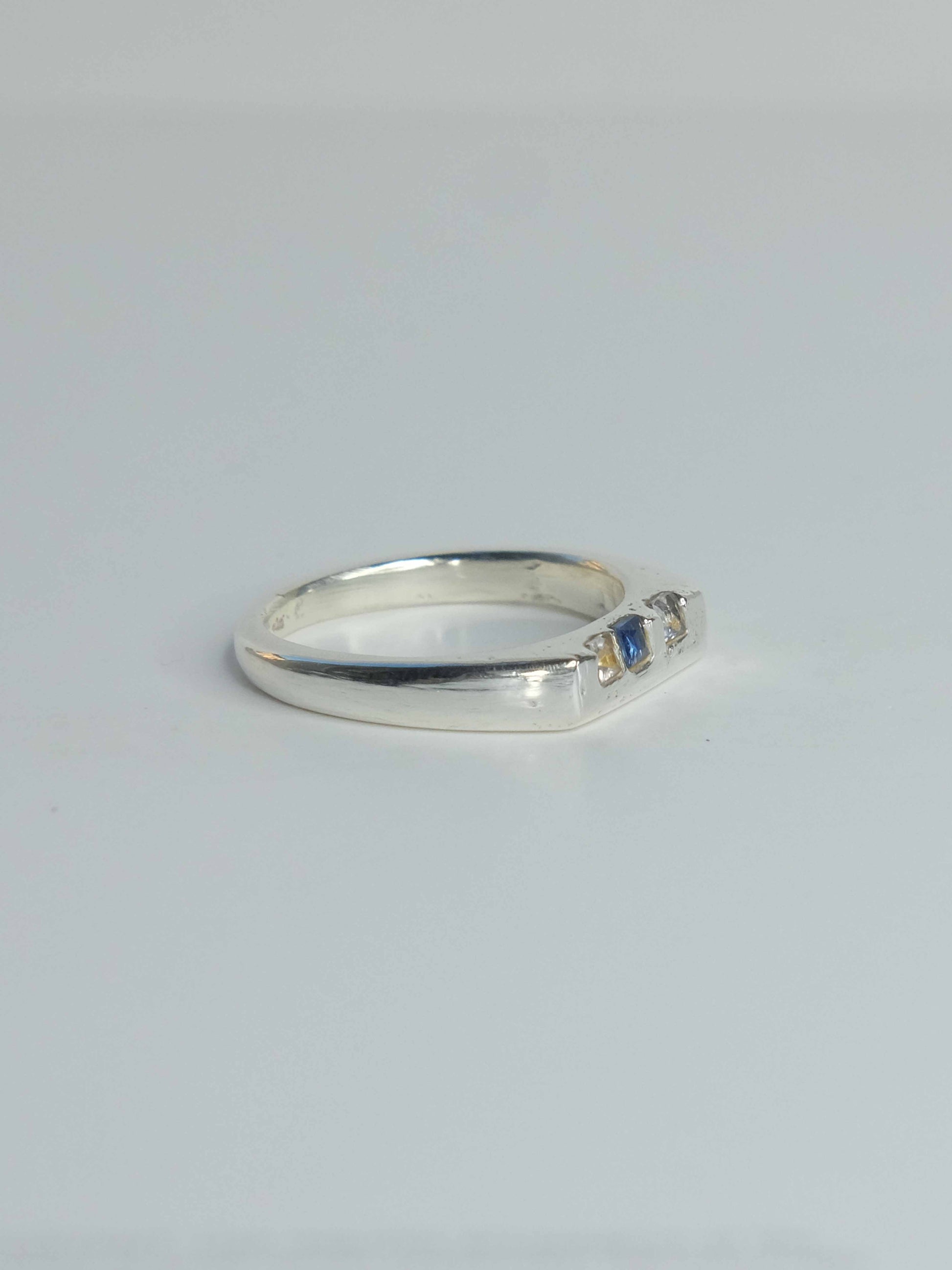 Handgefertigter Celestia Siegelring aus 925 Sterling-Silber mit glatter Oberfläche in schlanker Form, durch Sandguss gefertigt und blauen und transparenten Saphiren – designed und made in Berlin.