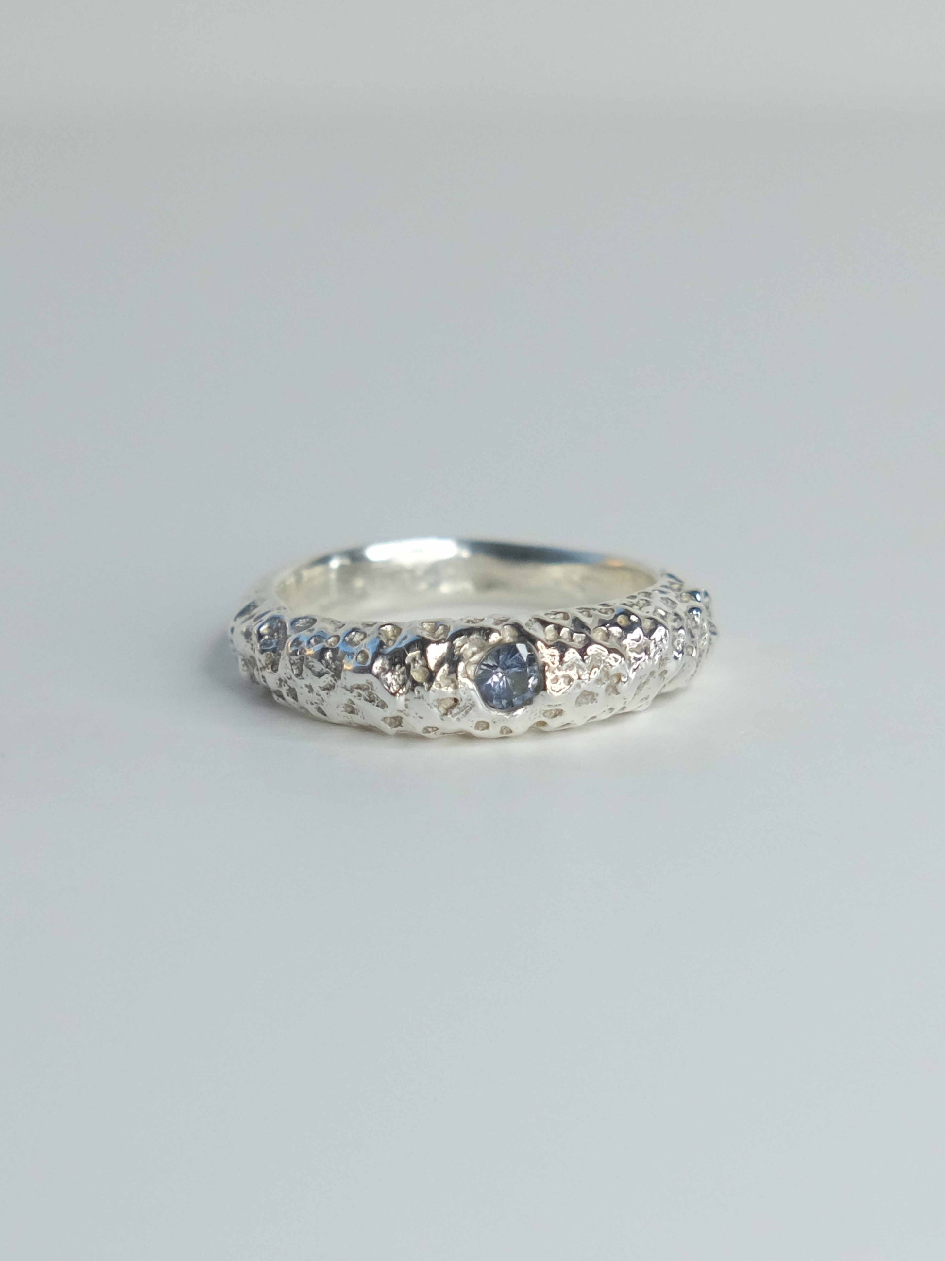 Handgefertigter Ring aus 925 Sterling-Silber strukturierter Oberfläche, durch Sandguss gefertigt, und blauem Saphire – designed und made in Berlin.