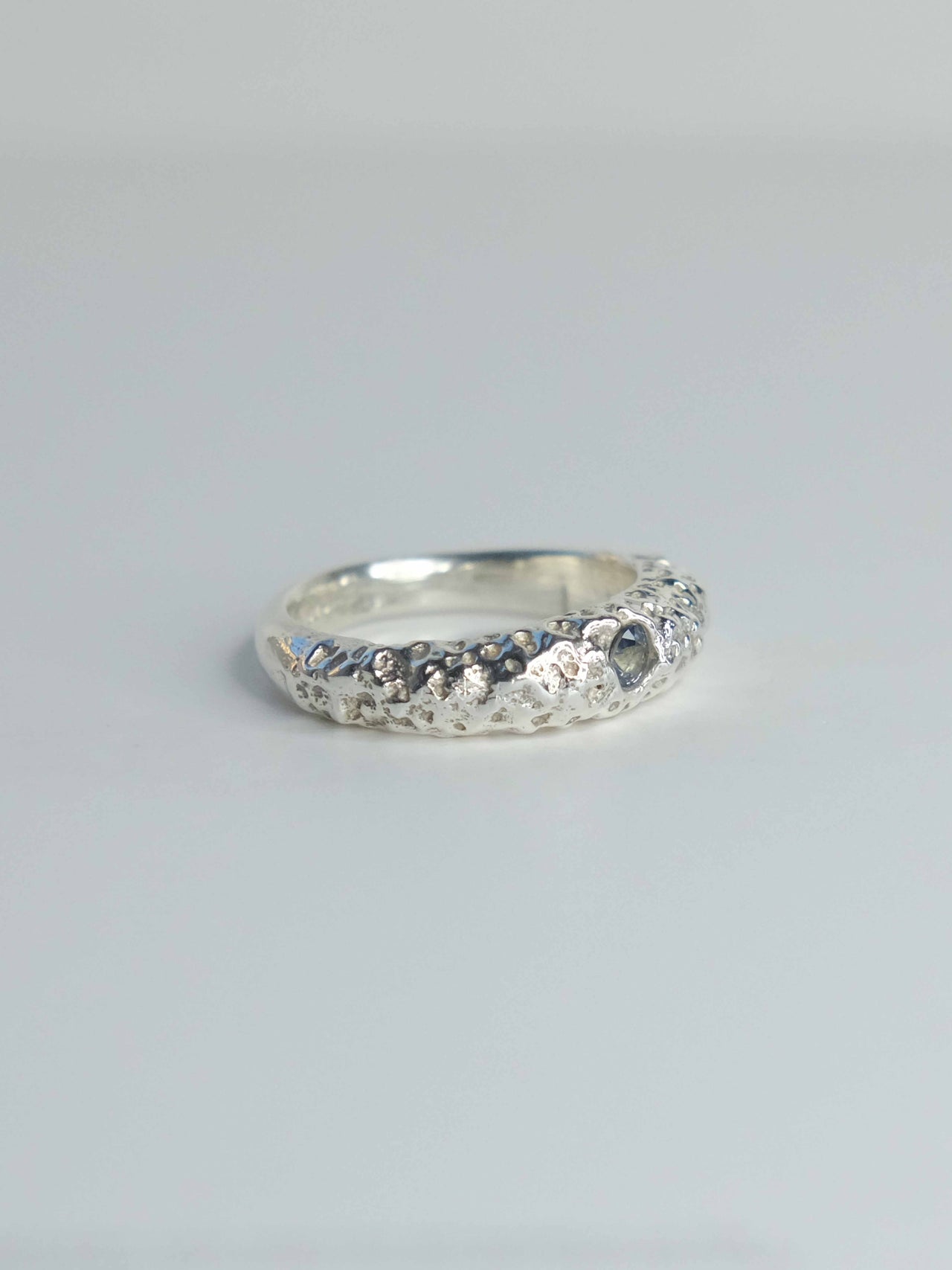 Handgefertigter Ring aus 925 Sterling-Silber strukturierter Oberfläche, durch Sandguss gefertigt, und blauem Saphire – designed und made in Berlin.