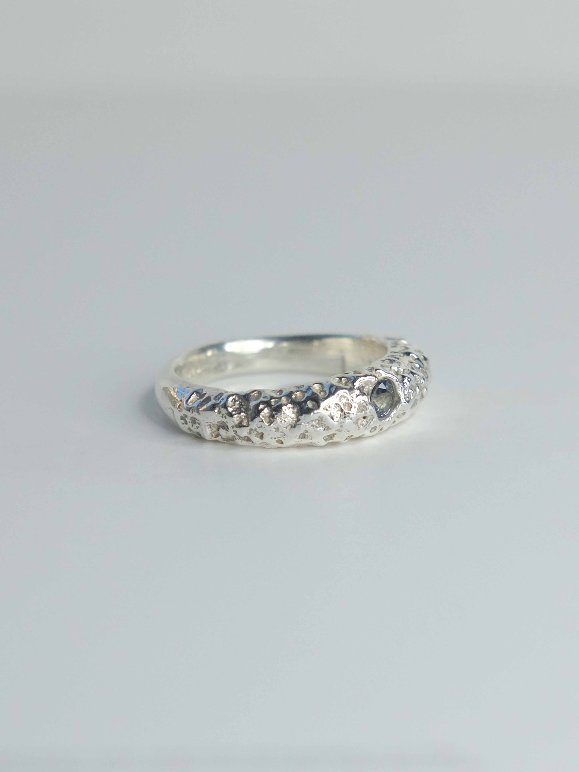 Handgefertigter Ring aus 925 Sterling-Silber strukturierter Oberfläche, durch Sandguss gefertigt, und blauem Saphire – designed und made in Berlin.