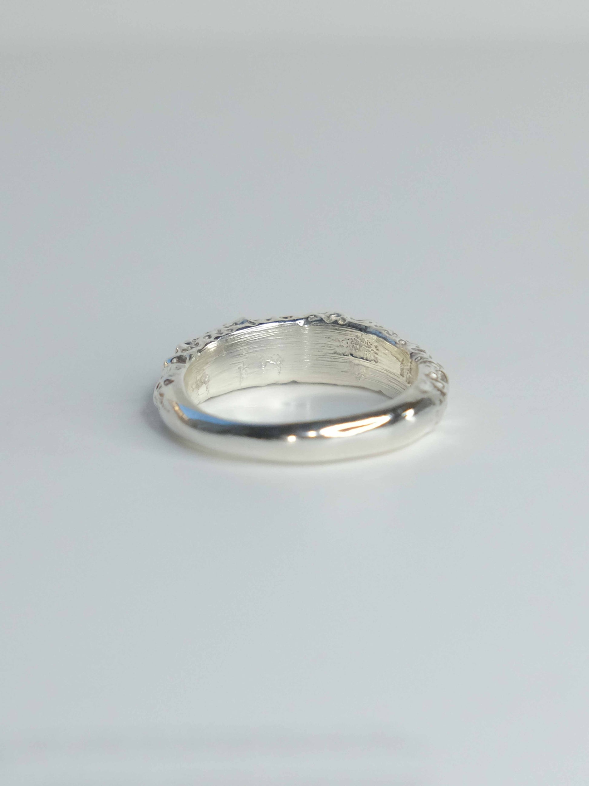 Handgefertigter Ring aus 925 Sterling-Silber strukturierter Oberfläche, durch Sandguss gefertigt, und blauem Saphire – designed und made in Berlin.