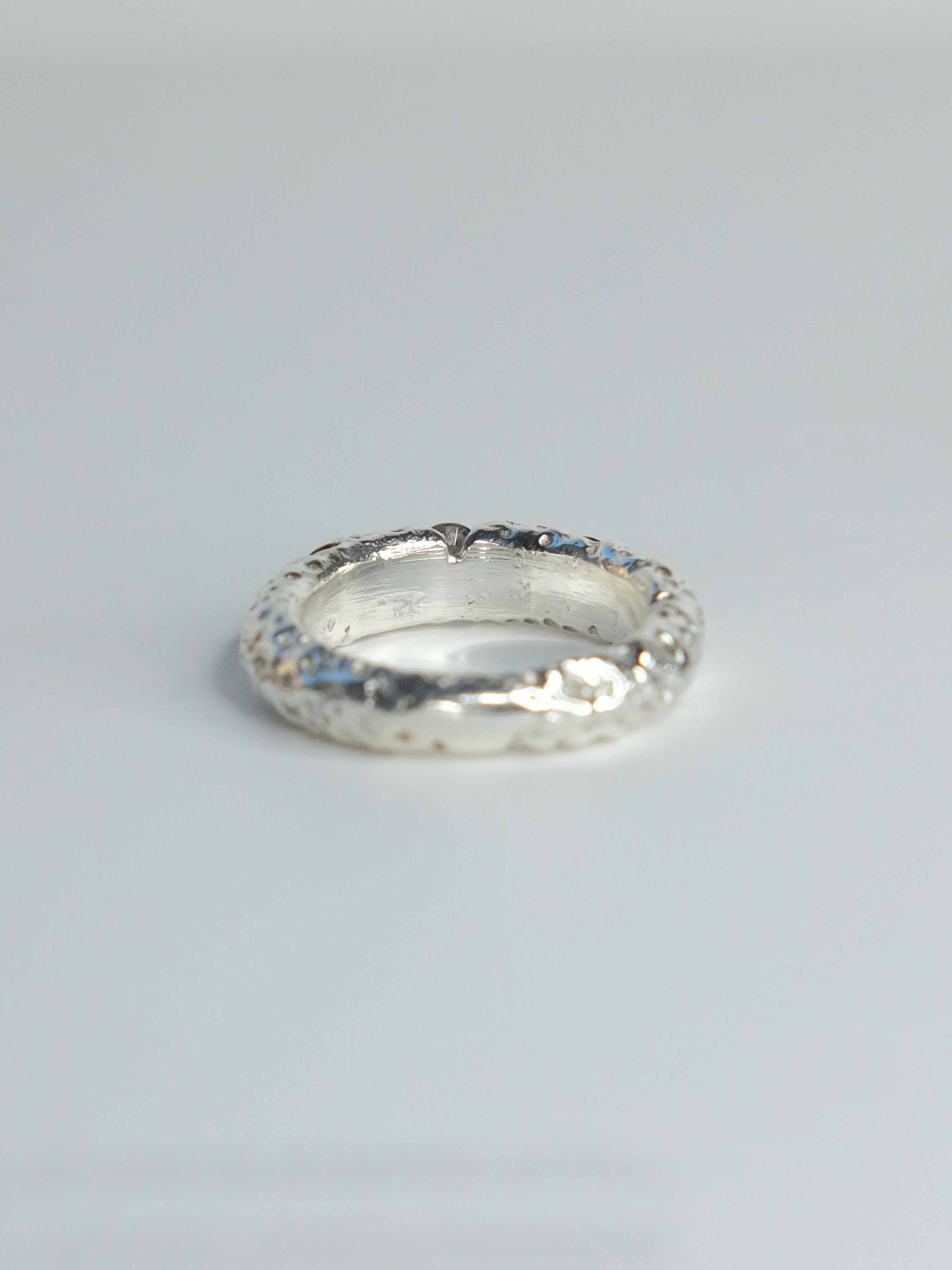 Handgefertigter Ring aus 925 Sterling-Silber strukturierter Oberfläche, durch Sandguss gefertigt, und drei grünen Saphiren – designed und made in Berlin.