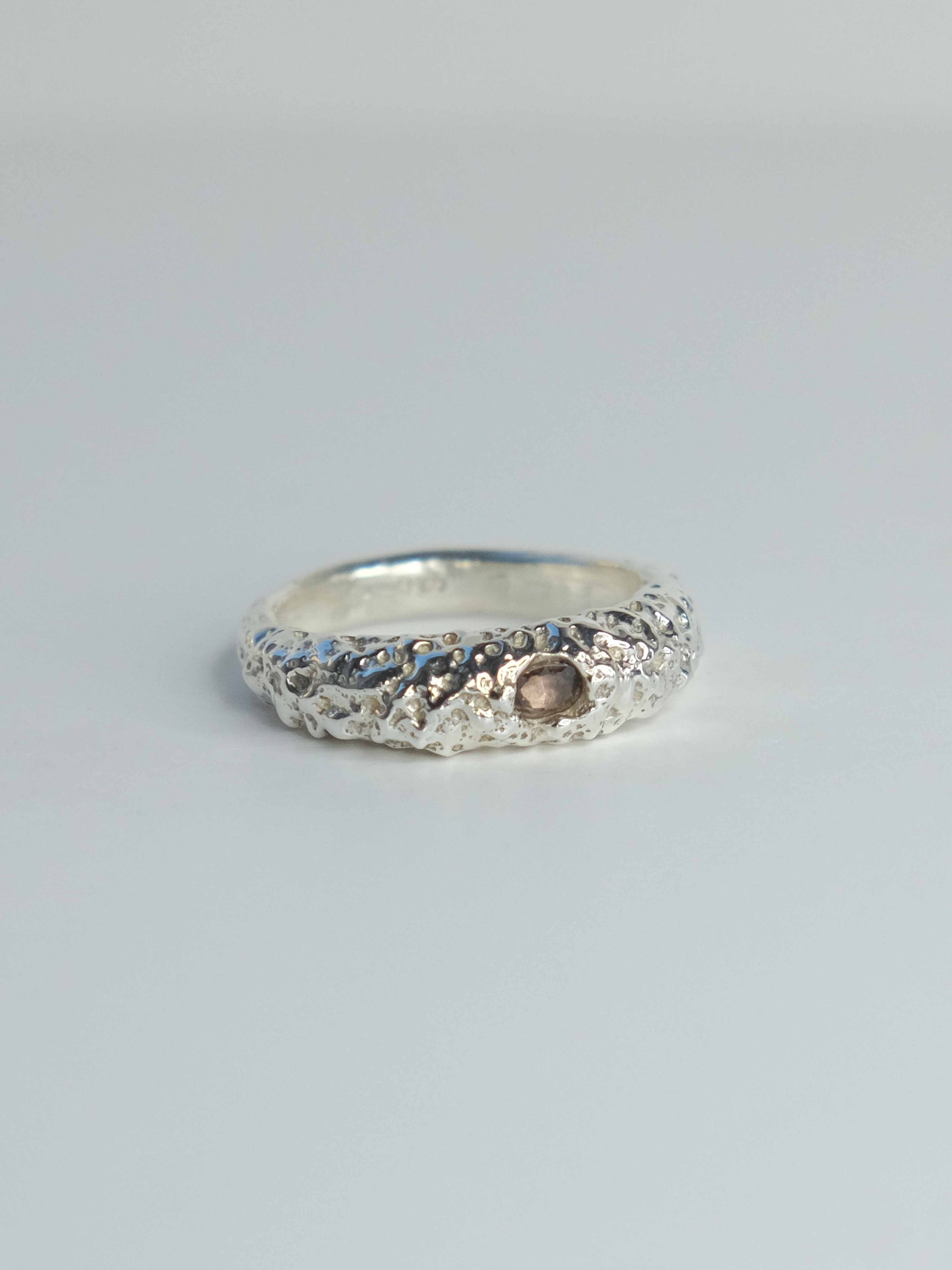 Handgefertigter Ring aus 925 Sterling-Silber strukturierter Oberfläche, durch Sandguss gefertigt, und lila braun Saphir – designed und made in Berlin.