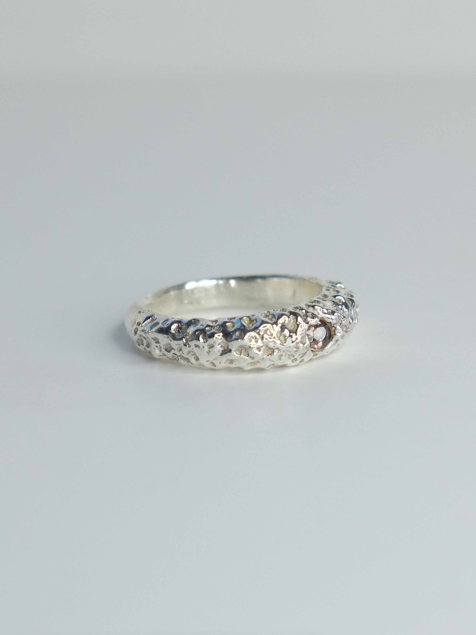 Handgefertigter Ring aus 925 Sterling-Silber strukturierter Oberfläche, durch Sandguss gefertigt, und lila braun Saphir – designed und made in Berlin.