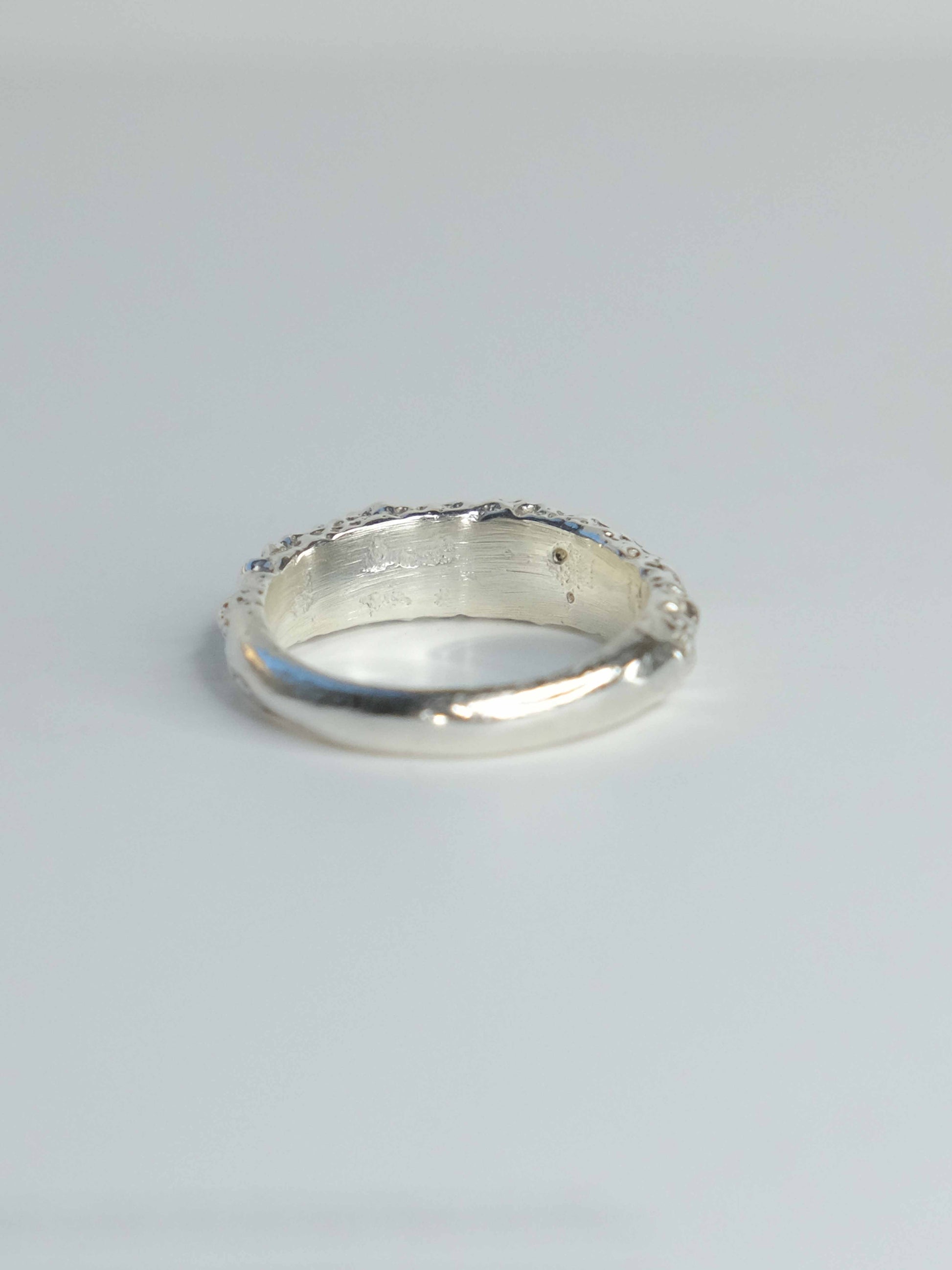 Handgefertigter Ring aus 925 Sterling-Silber strukturierter Oberfläche, durch Sandguss gefertigt, und lila braun Saphir – designed und made in Berlin.