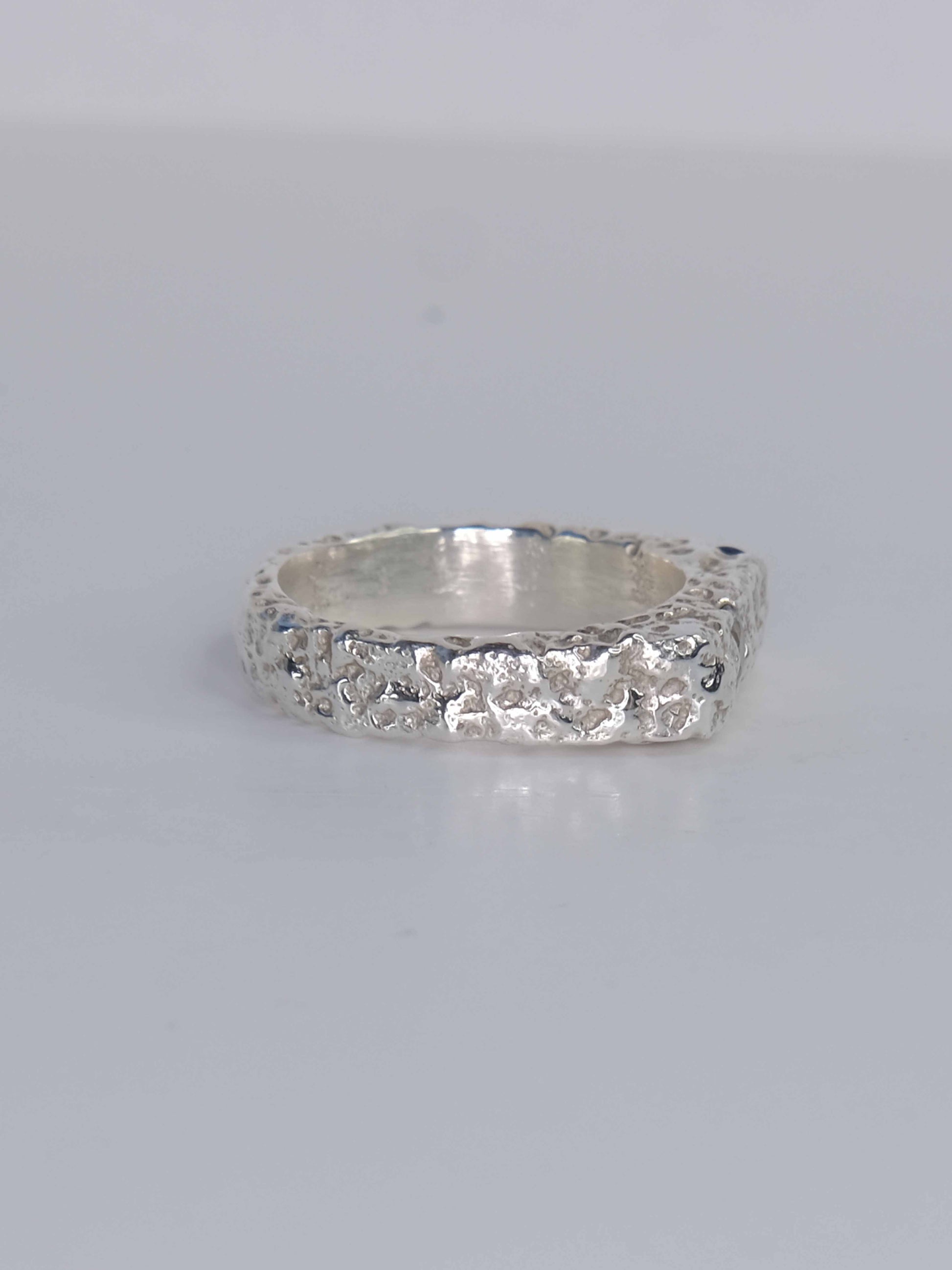 Handgefertigter Dune Siegelring aus 925 Sterling-Silber mit strukturierter Oberfläche in schlanker Form, durch Sandguss gefertigt und mit zwei blauen Saphiren – designed und made in Berlin.