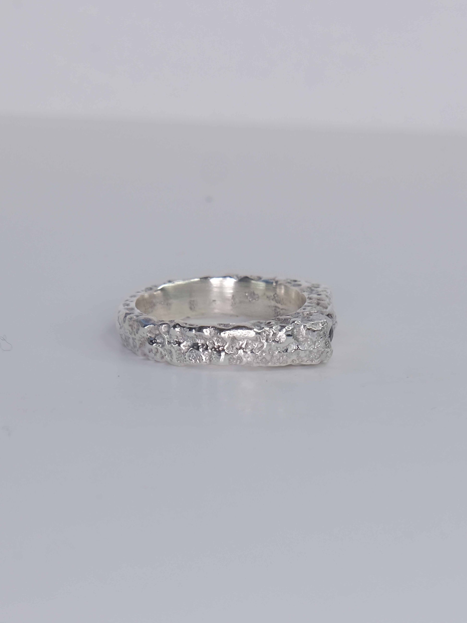 Handgefertigter Dune Siegelring aus 925 Sterling-Silber mit strukturierter Oberfläche in schlanker Form, durch Sandguss gefertigt und mit zwei violett und pink braunen Saphiren – designed und made in Berlin.