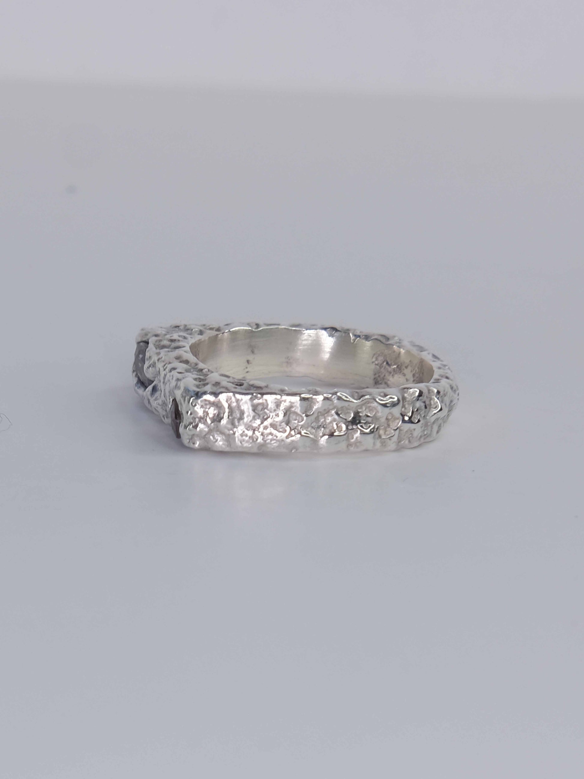 Handgefertigter Dune Siegelring aus 925 Sterling-Silber mit strukturierter Oberfläche in schlanker Form, durch Sandguss gefertigt und mit zwei violett und pink braunen Saphiren – designed und made in Berlin.