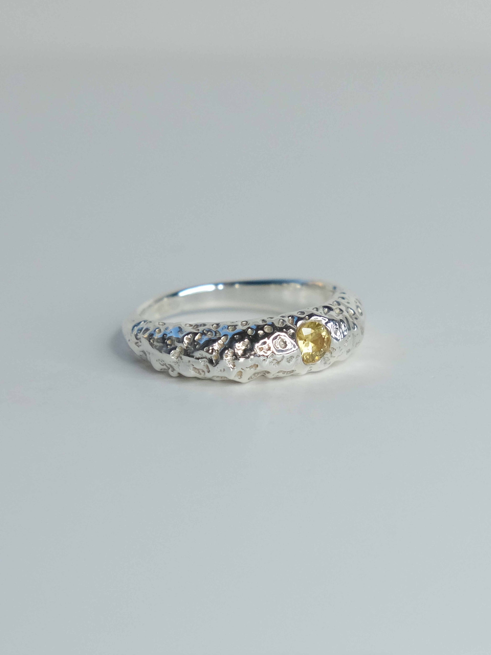 Handgefertigter Ring aus 925 Sterling-Silber strukturierter Oberfläche, durch Sandguss gefertigt, und gelbem Saphir – designed und made in Berlin.