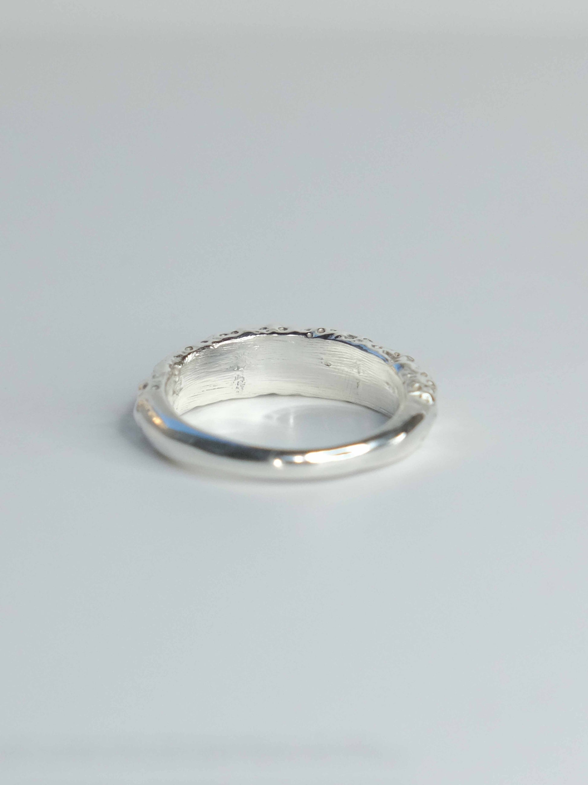 Handgefertigter Ring aus 925 Sterling-Silber strukturierter Oberfläche, durch Sandguss gefertigt, und gelbem Saphir – designed und made in Berlin.