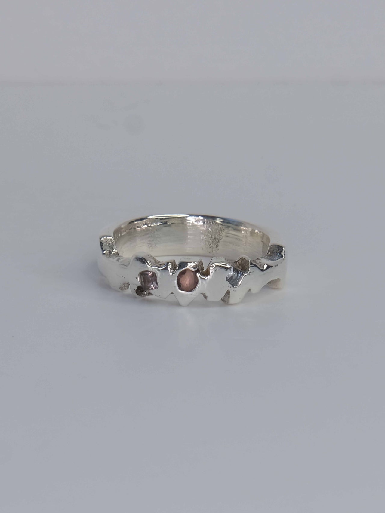 Tankwa Ring aus 925 Sterling-Silber mit strukturierten Oberflächen, die an die scharfen Wüstensteine des Tankwa Karoo Nationalparks erinnern. Verziert mit kleinen quadratischen Saphiren in verschiedenen Blau- und Lilatönen. Handgefertigt und designed in Berlin.